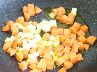 咖喱杂蔬,另起锅留底油将胡萝卜丁和葱花放入小火煸炒