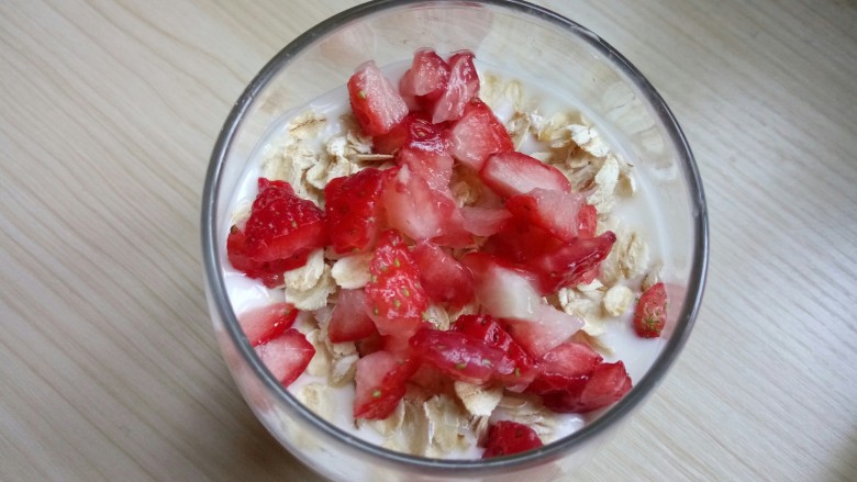 草莓酸奶燕麦杯,将草莓切成小丁放在燕麦上
