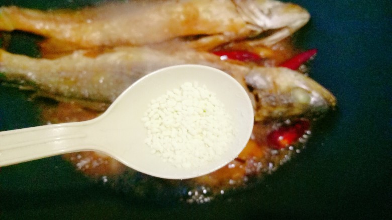干烧大黄鱼（内附煎鱼不破小窍门）,放入少许的<a style='color:red;display:inline-block;' href='/shicai/ 756'>鸡精</a>（可以尝一下咸淡，如果觉得淡的话可以加少许的盐，因为煎鱼的时候锅里撒盐了，所以正常是不用加的。）
