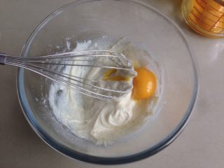 奥利奥蛋糕卷,分两次加入蛋黄，每加入一次拌均匀后，再加入下一次