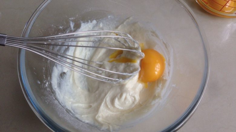 奥利奥蛋糕卷,分两次加入蛋黄，每加入一次拌均匀后，再加入下一次