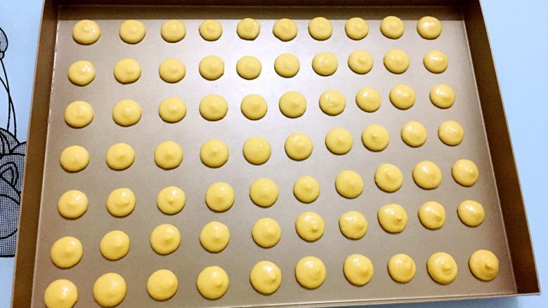 蛋黄小饼干,在烤盘上间隔的挤出圆形形状， 大小一致