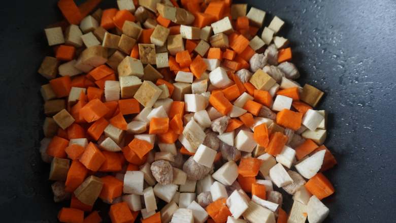 八宝辣酱,待肉的颜色变白之后，依次倒入胡萝卜、豆腐干和鸡腿菇