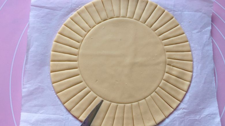 吉祥枣花馍,拿个圆形模具，在圆饼的中央位置轻轻压个印，再用刀在面饼的周围切出长宽一致的条。