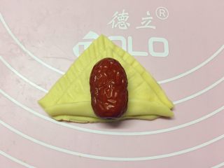 新年喜庆枣花馍,如图：在叠好的小三角上放一个红枣。（红枣提前泡发两分钟，然后清洗干净备用）