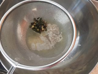 中式点心：千层酥,炸好的葱段用面粉筛滤出，直接趁热倒入面粉碗里；