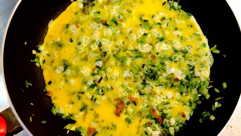 荞菜炒鸡蛋,先不要翻动，让鸡蛋液和菜在锅中摊熟。