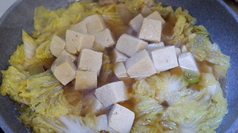 五花肉炖白菜冻豆腐,锅内水开后，加入冻豆腐。