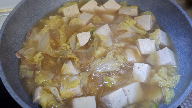 五花肉炖白菜冻豆腐,最后打开锅盖，将粉条与其他食材拌匀。