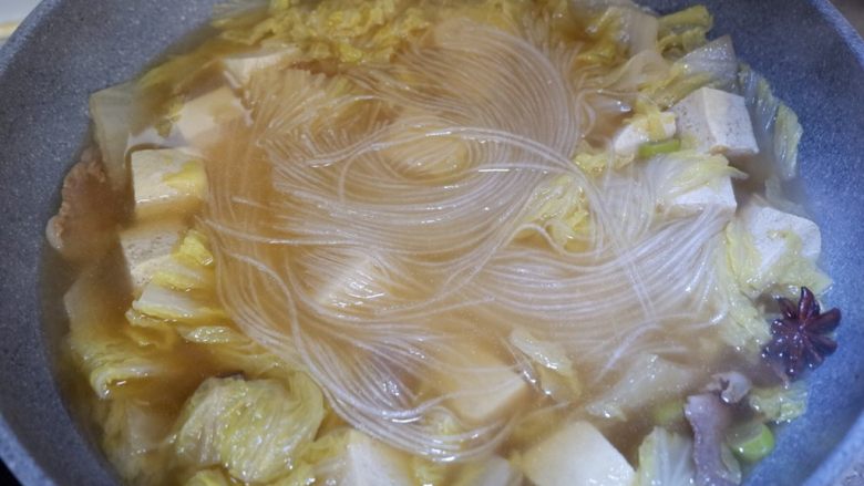 五花肉炖白菜冻豆腐,用锅铲压一下，让粉条完全浸泡在汤中。盖上盖子将所有材料煮熟。