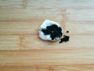 花样馒头——旅游青蛙,从和好的白色面团中取出一小块面团，加入少许竹炭粉揉成黑色面团。