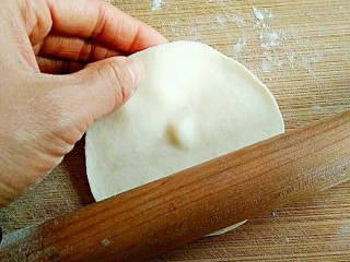 素饺子,将面剂压扁，擀成中间后边缘薄的饺子皮。