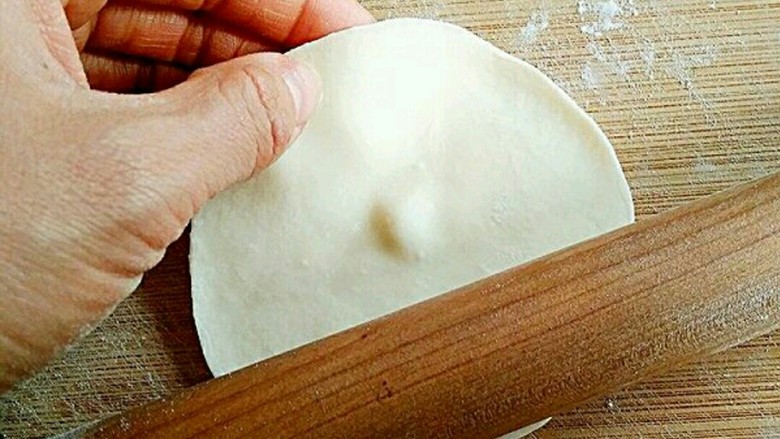素饺子,将面剂压扁，擀成中间后边缘薄的饺子皮。