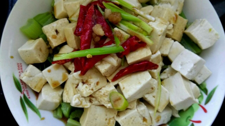 炝拌豆腐,把葱丝红辣椒放在豆腐上，把小碗中的调料浇到豆腐上