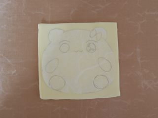 卡通早餐—熊猫芝士吐司,将油纸贴合在上面
