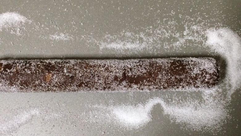可可杏仁饼干,将烤箱温热至180°C 把砂糖放在蝙蝠上，滚动冷冻的面团，覆盖整个。