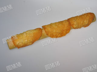 简单又美味的——杏仁瓦片酥,烤好的饼干乘着有些微热时，放在擀面杖上，折成弯形，放凉至变硬。