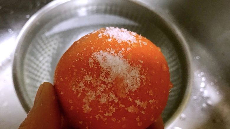 盐蒸橙子,橙子表面撒上适量盐揉搓