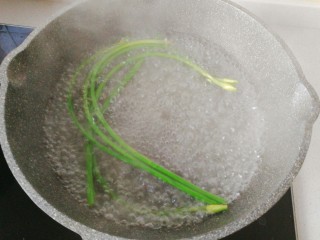 年菜~黄金福袋,锅中烧热水，先放蒜苔焯下水