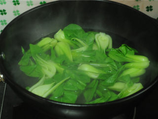 牛肉烧油菜,烧开一锅水，将青菜放进去汆烫好，上海青的片比较厚，汆烫的时候先将白色片放进去稍微烫一下，然后再整个叶片放进去