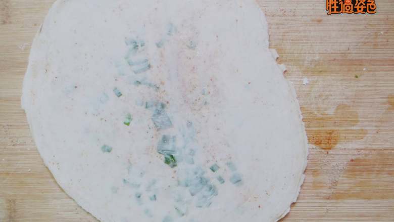 盘丝饼,用手捏把饺子皮的边缘，以防油和葱会漏出。然后用擀面杖从中间向外面按压