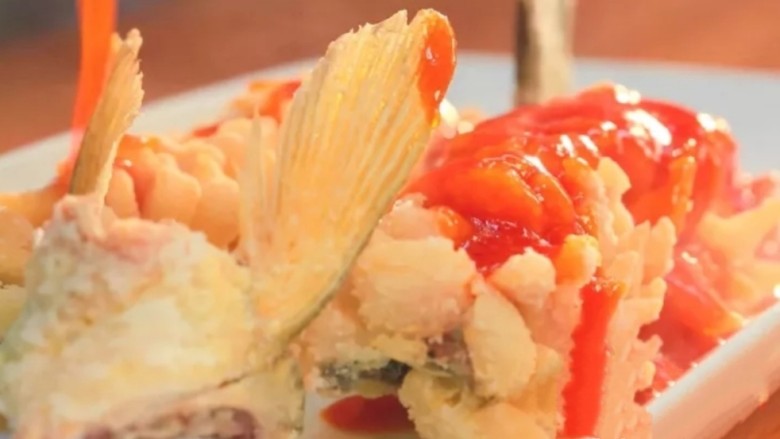 红茄松鼠脆鱼,四:装盘
将芡汁均匀地浇在鱼上，用筷子沾上酱汁，在鱼下巴两边点上红点，形成“松鼠眼睛”。