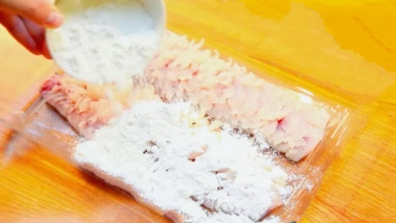 红茄松鼠脆鱼,腌制好鱼肉后，去掉葱花和姜丝，倒入1碗生粉，均匀涂到鱼肉表面和刀缝中。