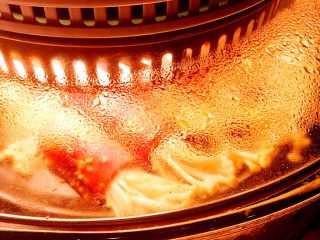 经光波烘焙的金针菇培根卷,烘焙过程中金针菇培根卷香气四溢，出现水分蒸发与油分流出。