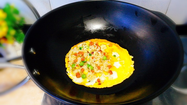趣味炒饭--满天星蛋包饭,将蛋皮再次回锅里回温下，将炒饭摆到一半蛋皮上。


