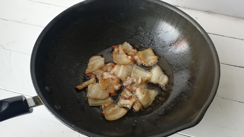 【干煸土豆片】 ,将锅内油倒出，留少许底油，下入五花肉片翻炒出油，将五花肉盛出