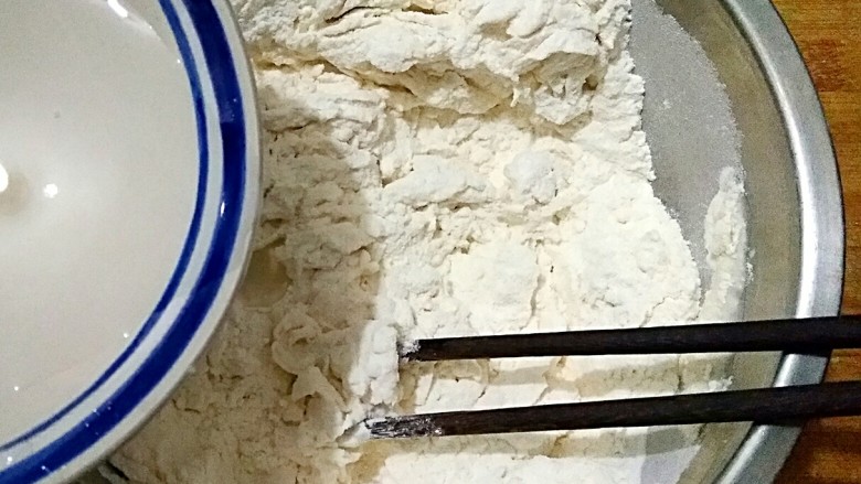椒盐盘丝饼,在面粉中少量多次加入温水，用筷子搅拌成雪花状。