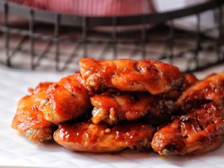 香辣烤翅,用烧烤酱代替叉烧酱均可，从烤箱取出鸡翅双面都需刷一层调味酱与蜂蜜。
