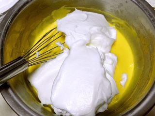 奶香纸杯小蛋糕,将打发好的蛋白分次加入到蛋黄糊中翻拌均匀