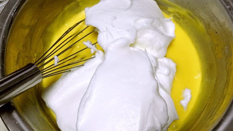 奶香纸杯小蛋糕,将打发好的蛋白分次加入到蛋黄糊中翻拌均匀