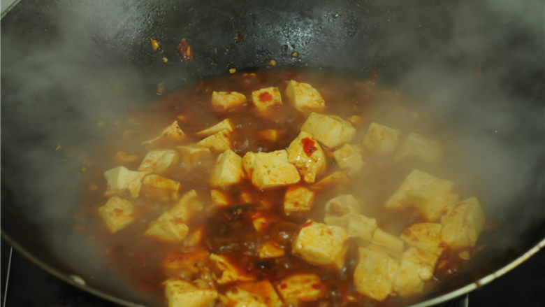 红烧豆腐,烧开后放入豆腐、大火烧煮一分钟，为了避免糊锅，中间适度旋转锅身，取一半水淀粉勾芡，继续旋动锅身烧煮大约一分钟，再放剩下的水淀粉，