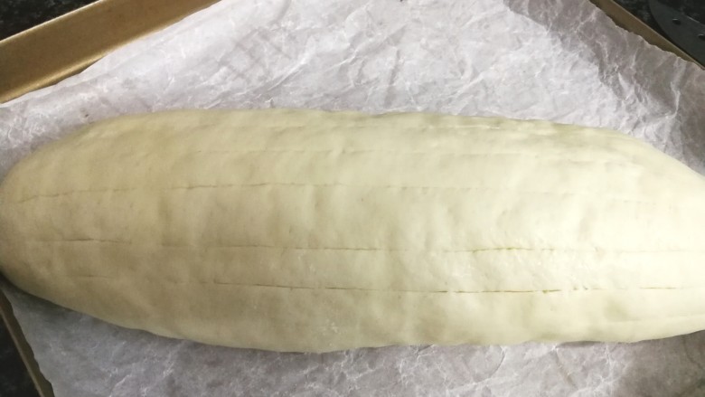 抹茶麻薯面包(一次发酵法),发酵好的面包胚，用利刀浅浅地竖划几刀