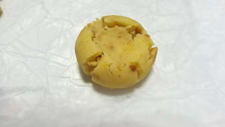 果仁玛格丽特饼干,用大拇指在小球中间垂直按下，使四周出现自然的裂纹。