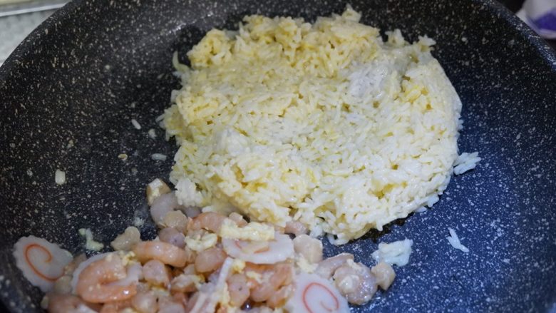 鸣门海鲜炒饭,将米饭放入，翻炒至蛋液凝固