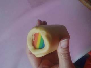 彩虹爱心饼干,取出冻硬的彩虹爱心条，用最早分割出来的原味面团包裹，并揉成圆柱状，再次放冰箱冻硬。