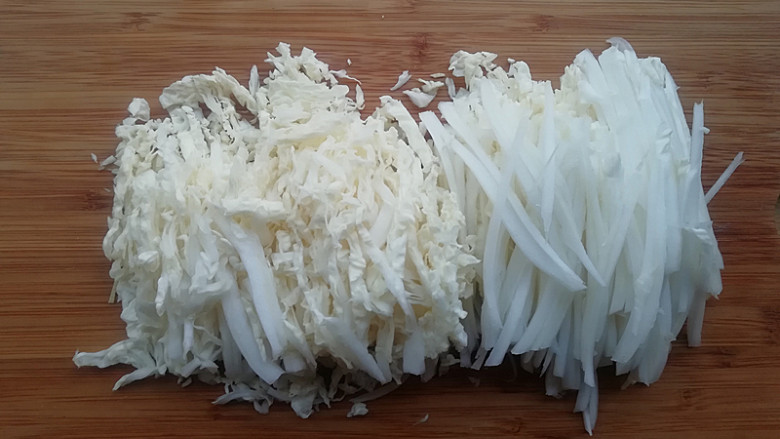 【东北家常凉菜】,将白菜帮较厚的部分用刀片开两层，在切成细丝