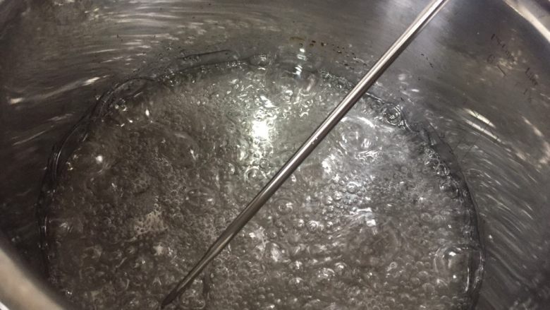 水饴版花生牛轧糖,把材料1所有物品放入厚底奶锅中熬糖，中火煮沸，改为小火，糖全部融化之后可以用筷子搅拌一下，我们的目标温度是140度至143度