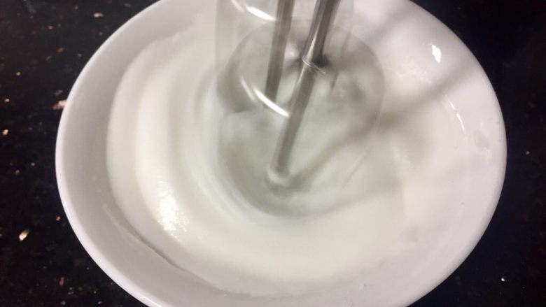 水饴版花生牛轧糖,等糖浆温度到达120度时，把10g细砂糖分三次倒入蛋清中打发到干性发泡，糖浆从120度到140度需要一定的时间，所以请认真打发蛋白霜