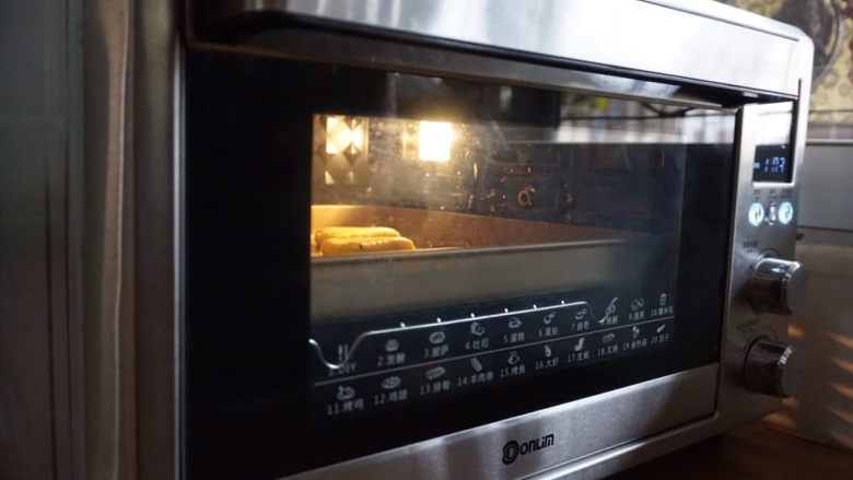 旅行青蛙的葡萄干烤饼,将东菱K40C烤箱预热到上下火180度，烤盘放在中下层，烘烤20分钟左右。