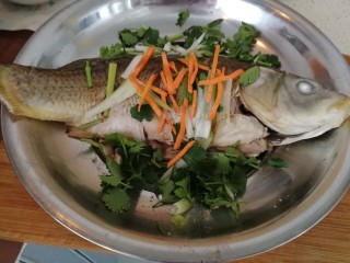 年夜菜_麻辣清蒸江鲫鱼&一锅两吃,两条鱼分别装盘，撒上葱丝，胡萝卜丝和香菜丝。