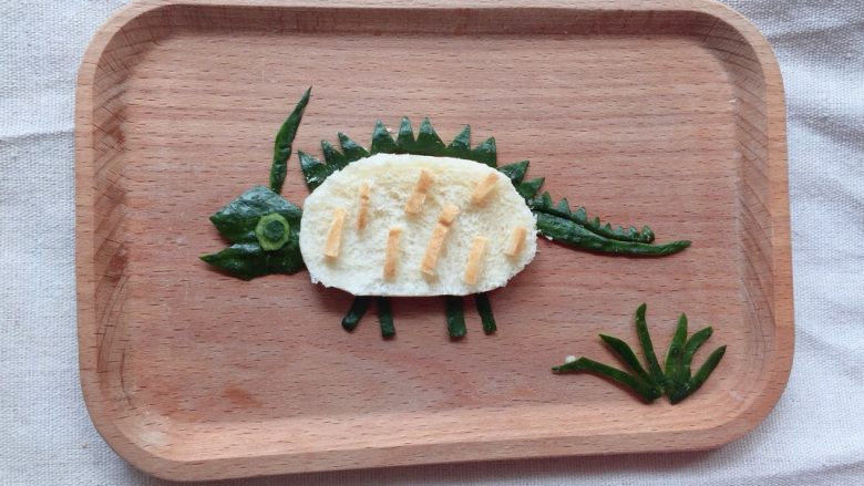 #宝宝辅食#乔治的恐龙 12M+,用吐司边剪出小条装饰恐龙身体，黄瓜皮剪出小草