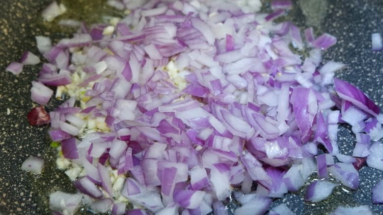 麻辣手丝杏鲍菇,锅内热油，先加入蒜末洋葱碎炒香。