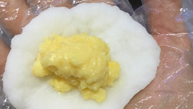 奶黄冰皮月饼,将面团擀成圆形薄片，包入奶黄馅