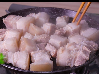 干豆角红烧肉,将五花肉放入平底锅在小火煎制