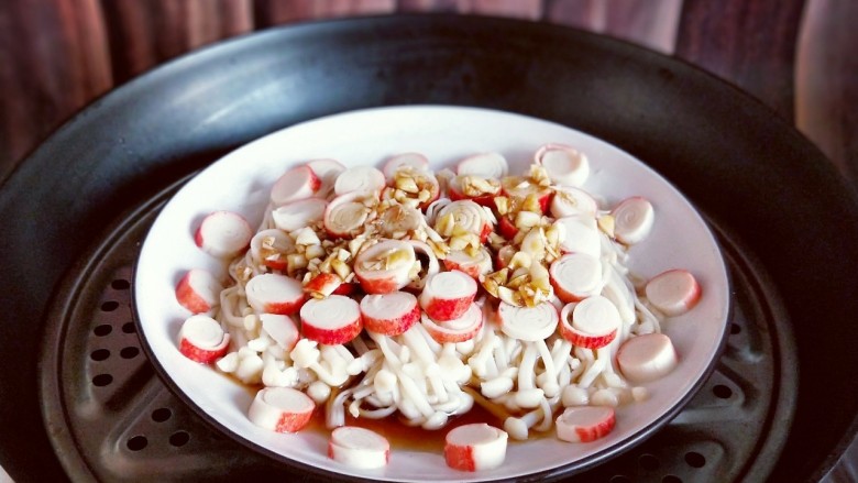 新年必备的双味儿蟹肉蒸金针菇,锅中加水烧开后将盘子放在蒸屉上，隔水蒸8分钟即可。