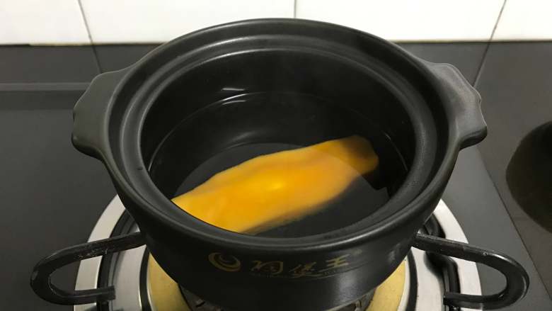 芒果椰汁黑米粥 ,先把芒果核放入煮3分钟上。